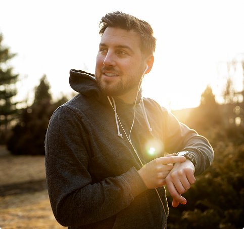 A man wearing a dark hoodie, standing casually with a neutral expression. A man wearing a dark hoodie, standing casually with a neutral expression.