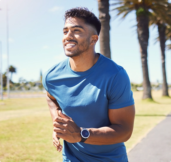 A man runs along a path lined with palm trees, enjoying the sunny outdoor scenery. A man runs along a path lined with palm trees, enjoying the sunny outdoor scenery.
