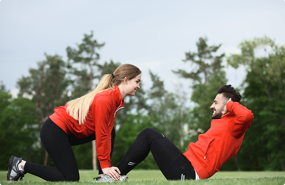 A man and woman are exercising together on a grassy field, demonstrating various fitness routines. A man and woman are exercising together on a grassy field, demonstrating various fitness routines.