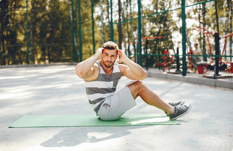 A man exercises on a green mat, focusing on his fitness routine in a bright, open space. A man exercises on a green mat, focusing on his fitness routine in a bright, open space.