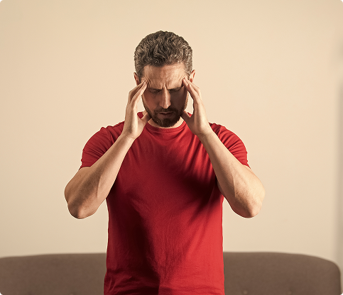 A man in a red shirt is holding his head, appearing distressed or deep in thought. A man in a red shirt is holding his head, appearing distressed or deep in thought.