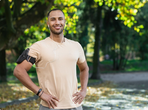 A man stands in a park with his arms crossed, looking thoughtfully at the surroundings. A man stands in a park with his arms crossed, looking thoughtfully at the surroundings.
