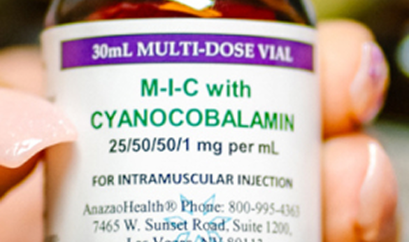 A person holding a bottle of ascorbic acid, showcasing the label and the clear liquid inside the bottle.