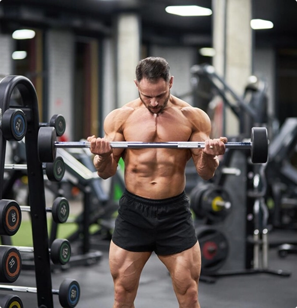 Muscular man lifting a heavy barbell in a gym, showcasing strength and focus during his workout.