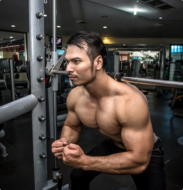 A man performs a squat in a gym, demonstrating strength and proper technique.