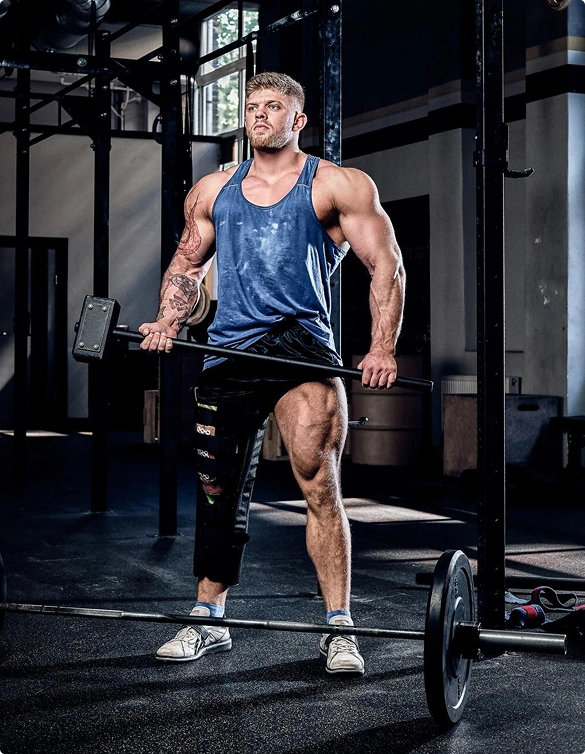 A man exercising with a barbell in a gym, demonstrating strength and dedication to fitness.