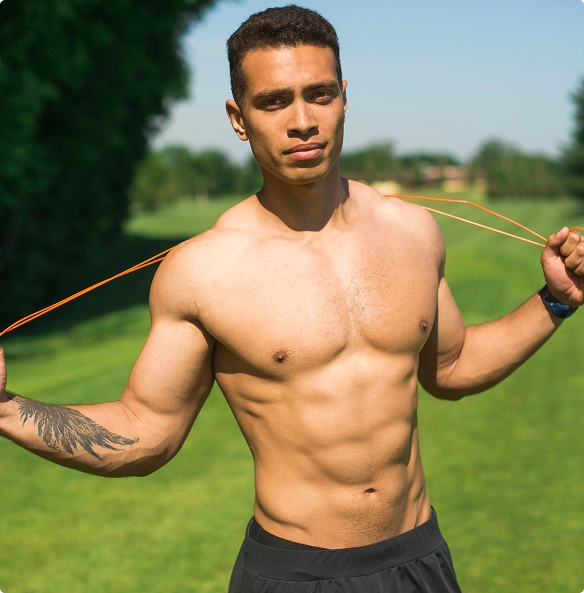 A shirtless man gripping a rope tightly in both hands, showcasing his muscular build. A shirtless man gripping a rope tightly in both hands, showcasing his muscular build.