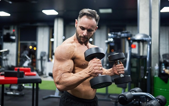 A man is engaged in weightlifting at a gym, demonstrating strength training with weights.