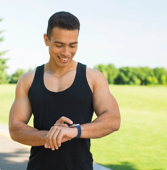 A man gazes at his smartwatch, checking notifications or time on the device. A man gazes at his smartwatch, checking notifications or time on the device.
