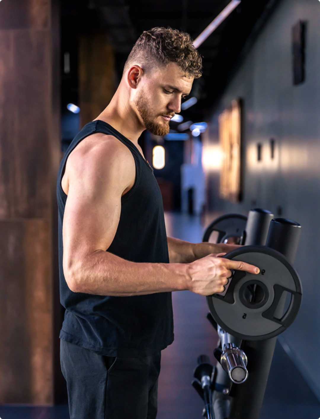 A man exercises on a gym machine, focusing on strength training in a fitness center.
