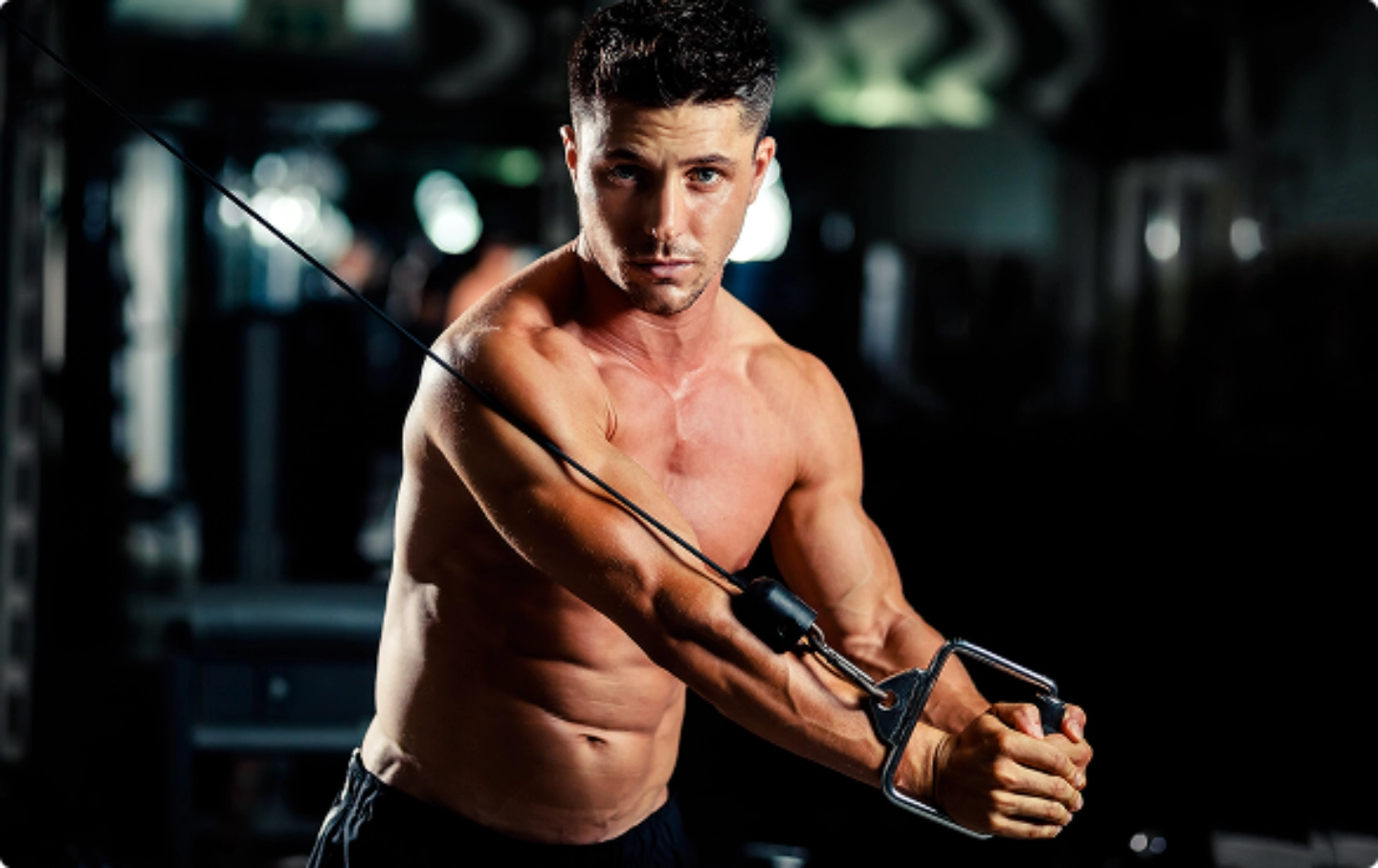 A man training on a cable machine to improve energy and overall wellness.