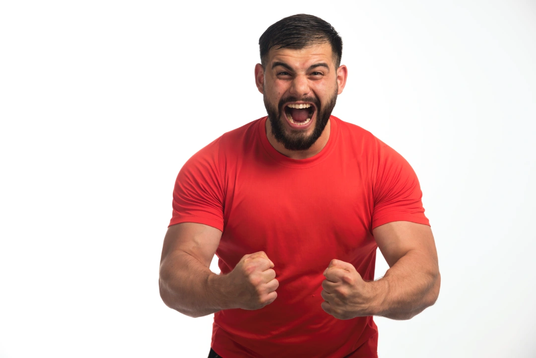 sportive-man-red-shirt-demonstrating-his-arm-muscles-screaming