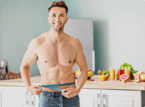 In a kitchen, a shirtless man uses a measuring tape, likely assessing measurements for a renovation or design task.
