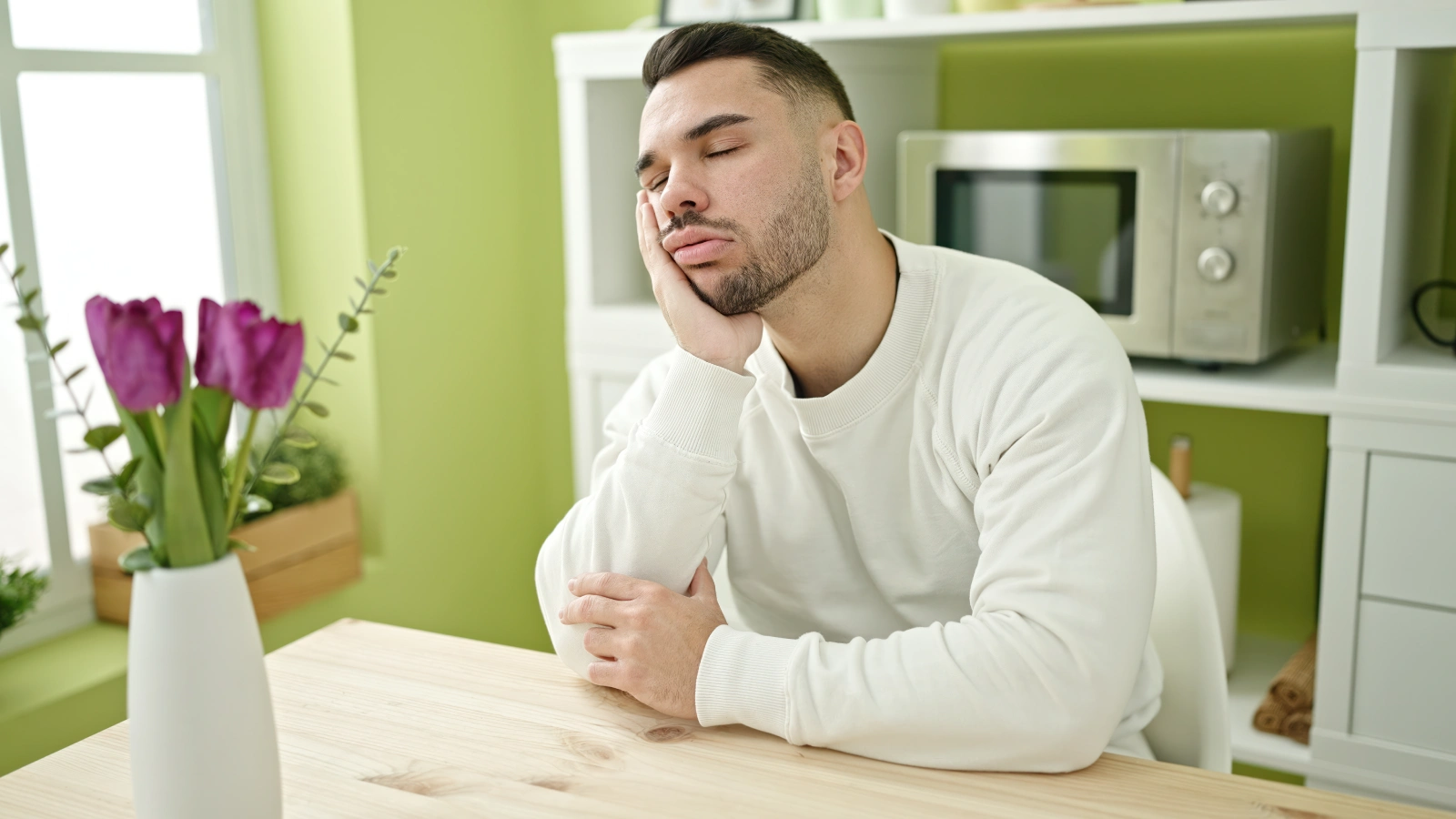 young-hispanic-man-sitting-table-sleeping-dinning-room