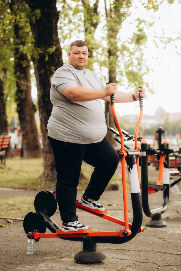 A bearded man running along a scenic path surrounded by greenery young-overweight-man-running-outdoors-fitness-lifestyle-high-quality-photo