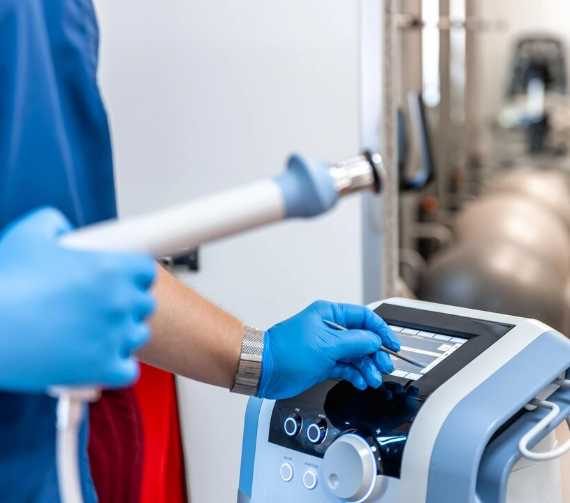 A person wearing blue gloves operates an electric machine, focused on their task.